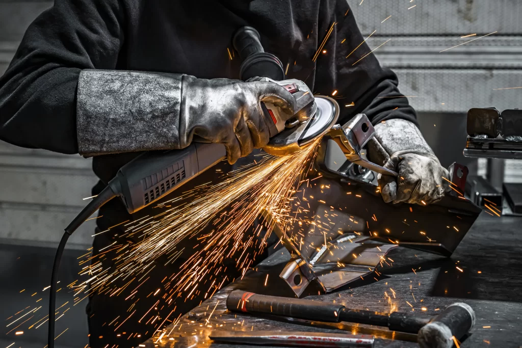 worker grinding a piece of metal